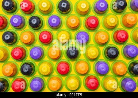 Le capsule di caffè compostabile. Colorate le cialde di caffè espresso, eco friendly, privo di alluminio con anello verde su sfondo giallo, vista dall'alto Foto Stock