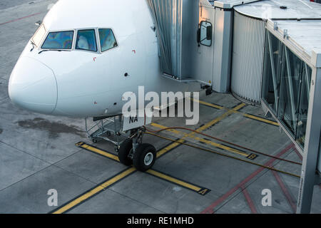 Aeromobili con corridoio di passaggio/tunnel essendo preparato per la partenza da un aeroporto internazionale - i passeggeri a bordo di un aereo in un aeroporto moderno Foto Stock