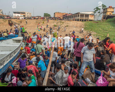 Iquitos, Perù - Sep 21, 2017: una folla di persone locali su un bordo nave da carico e una costa fangoso di una porta attraverso il fiume del Amazon in Iguitos. Foto Stock