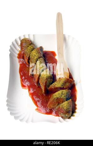 Currywurst con salsa al curry su un piatto di carta, hot salsicce di maiale Foto Stock
