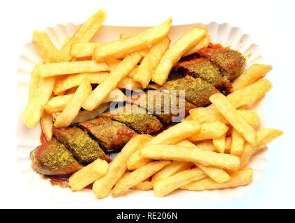 Currywurst con patatine e salsa al curry su un piatto di carta, hot salsicce di maiale Foto Stock
