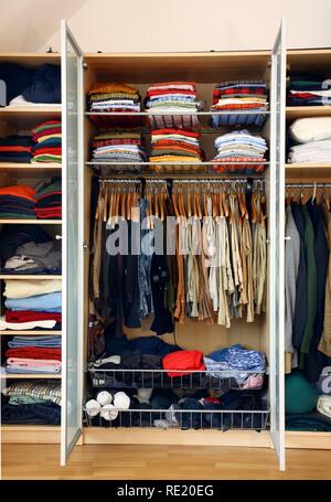 Un uomo di guardaroba, abbigliamento di tutti i tipi o appendere giacente in differenti compartimenti Foto Stock