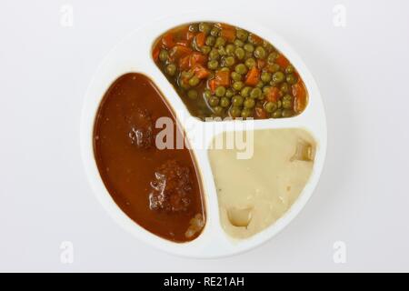 Pasto in un contenitore in plastica, precotti, porzionati per una persona, polpette di carne con piselli, carote e purè di patate Foto Stock