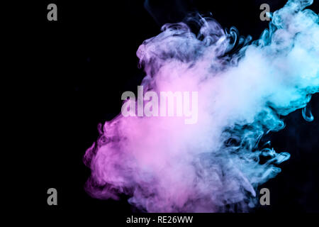 Nuvole di isolato di fumo di colore: blu, rosso, verde, rosa; scorrimento su uno sfondo nero nel buio vicino. Foto Stock