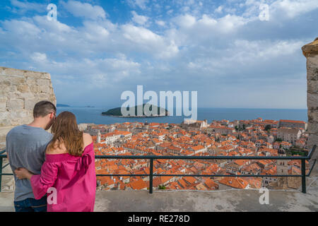 Dubrovnik Croazia - Aprile 2018 : Coppia giovane stare in piedi in cima alle mura della vecchia città di Dubrovnik ammirando il panorama della città storica di seguito Foto Stock