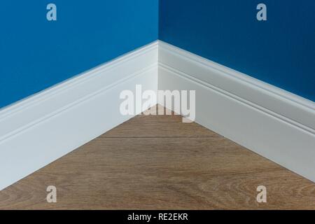 Stampaggio in un angolo. Blu parete opaca con laminato rovere immitating texture. Foto Stock