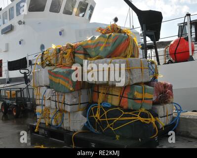 Coast Guard trasferita la custodia dei due sospetti di contrabbandieri e più balle di cocaina alla legge federale alle autorità incaricate di far rispettare la legge a Coast Guard Settore San Juan a San Juan, Puerto Rico nov. 10, 2016. In totale, 1.158 libbre di cocaina con una stima di valore all'ingrosso di $13.1 milioni di euro sono stati sequestrati come risultato multi-agenzia legge gli sforzi a sostegno dell'operazione Unified risolvere e funzionamento dei Caraibi di protezione. Foto Stock