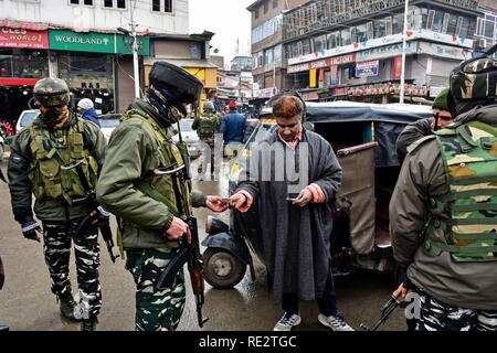 Srinagar, India. 19 gen 2019. Le forze di governo visto il controllo di una carta di identità del commuter durante l'operazione. Un massiccio Cordon e operazione di ricerca (CAS) mediante le forze di governo ha lanciato nel cuore di Srinagar città, Lal Chowk la ricerca giunge un giorno dopo la granata attacco ha avuto luogo nella località. Credito: SOPA Immagini limitata/Alamy Live News Foto Stock