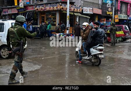 Srinagar, India. 19 gen 2019. Un soldato di paramilitari visto stoping uno scooter durante l'operazione. Un massiccio Cordon e operazione di ricerca (CAS) mediante le forze di governo ha lanciato nel cuore di Srinagar città, Lal Chowk la ricerca giunge un giorno dopo la granata attacco ha avuto luogo nella località. Credito: SOPA Immagini limitata/Alamy Live News Foto Stock