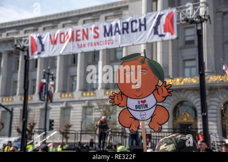 San Francisco, Stati Uniti d'America. 19 gennaio, 2019. Le donne di Marzo a San Francisco inizia con un rally al Civic Center Plaza di fronte al Palazzo del Municipio. Come la folla si raduna prima del rally, un manifestante detiene un segno beffardo Donald Trump come un neonato che indossa un "Io amo Putin' onesie. Il presidente della testa è fatto per assomigliare ad una pesca, un probabile riferimento di impeachment. Credito: Shelly Rivoli/Alamy Live News Foto Stock