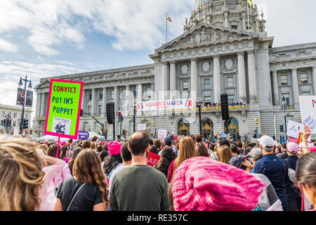 San Francisco, Stati Uniti d'America. 19 gen 2019. I partecipanti per le donne del marzo evento segni di attesa con vari messaggi; la tappa di rally e il municipio edificio visibile in background Foto Stock