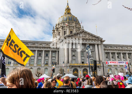 San Francisco, Stati Uniti d'America. 19 gen 2019. I partecipanti per le donne del marzo evento segni di attesa con vari messaggi; la tappa di rally e il municipio edificio visibile in background Foto Stock