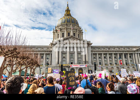 San Francisco, Stati Uniti d'America. 19 gen 2019. I partecipanti per le donne del marzo evento segni di attesa con vari messaggi; la tappa di rally e il municipio edificio visibile in background Foto Stock