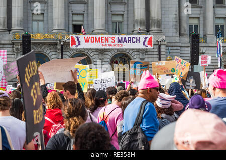San Francisco, Stati Uniti d'America. 19 gen 2019. I partecipanti per le donne del marzo evento segni di attesa con vari messaggi; la tappa di rally e il municipio edificio visibile in background Foto Stock