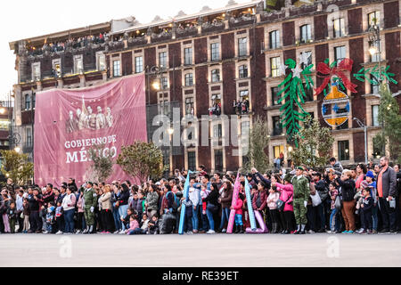 La polizia militare cadre tenendo giù il Messico bandiera nazionale al Zocalo, Città del Messico, con la gente a guardare Foto Stock