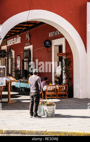 Un cibo di strada venditore accanto al ristorante elegante in Cholula, Messico Foto Stock