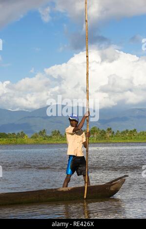 Uomo locale la navigazione nei canali della riserva Andrifotra, Maroantsetra, Madagascar, Africa Foto Stock