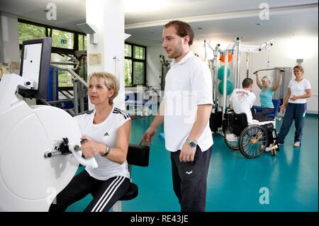 I pazienti durante la forza muscolare training su varie macchine in una palestra, fisioterapia, terapia fisica in un malattie neurologiche Foto Stock
