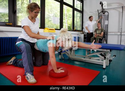 I pazienti durante la forza muscolare della formazione in una palestra, esercizi ginnici, fisioterapia, terapia fisica in un malattie neurologiche Foto Stock