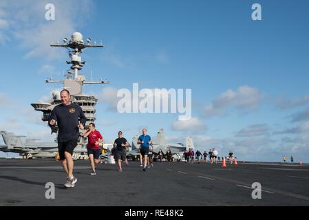 Oceano Pacifico (nov. 27, 2016) marinai eseguire un 5k " Turchia trotto' sponsorizzata dalla morale, benessere e svaghi sul USS John C. Stennis' (CVN 74) ponte di volo. John C. Stennis è in corso per condurre la formazione di routine e partecipare nella legislazione nazionale in materia di Pearl Harbor giorno del ricordo di eventi nelle Hawaii. Foto Stock