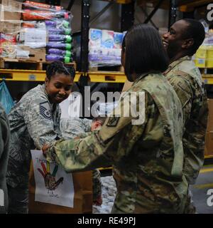 Master Sgt. Phyllis Brooks, 1a lottare contro lo squadrone di comunicazioni operazioni di combattimento il capo della sezione, riempie un sacchetto con forniture di grazie per il giorno del ringraziamento a evento Vogelweh Air Base. Germania, nov. 19, 2016. Gli studenti provenienti da Kaiserslautern circostanti Comunità Militare scuole elementari decorate borse marrone con piume e disegni di tacchine e di tacchini. Ogni pacchetto incluso un 10-12 lb. tacchino congelati, una teglia, mix di farcitura, il sugo di carne, salsa di mirtilli, purè di patate e verdure, patate, cena rotoli, una torta congelata, e $25 Carta regalo Visa. Foto Stock