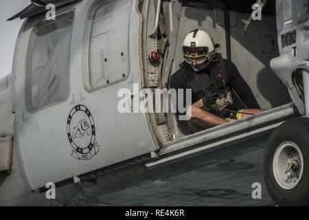 Golfo Arabico (nov. 23, 2016) Petty Officer di terza classe Bretton Gilbert guida il pilota di un MH-60S Sea Hawk elicottero assegnato per il polveroso cani di elicottero di mare squadrone di combattimento (HSC) 7 durante un rifornimento verticale a bordo del combattimento veloce nave appoggio USNS Arctic (T-AOE 8). Artico è implementato il supporto di coalizione forze marittime navi negli Stati Uniti Quinta Flotta area di operazioni. Foto Stock