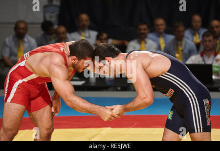 Bucarest, Romania - 27 Luglio 2011: due lottatori muscolare di benna mordente in un intenso sforzo per il controllo del guadagno per la takedown durante Junior Wrestling Giornate mondiali Foto Stock