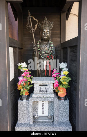 Kumamoto, Giappone - 13 Novembre 2018: santuario buddista con la statua del Buddha con corona e pellegrini personale come un simbolo di potere Foto Stock