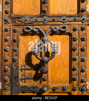 Dettaglio della porta di legno e sportello respingente presso l'ingresso principale della Casa del Cordon Palace a Burgos, Spagna Foto Stock