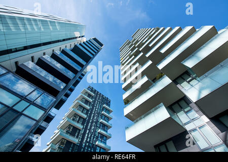 Bassa angolazione prospettica convergente di moderni grattacieli di Milano con ampi balconi contro un soleggiato chiaro cielo blu Foto Stock
