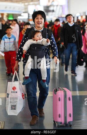 (190120) -- Pechino, 20 gennaio, 2019 (Xinhua) -- Passenger Chen Xiaolin arriva all'Aeroporto di Xianyang con il suo bambino per prendere un volo a Guangzhou, Cina del sud della provincia di Guangdong, in Xianyang, Cina nord-occidentale della provincia di Shaanxi, il 6 febbraio 2018. Tornando alla città di appartenenza rimane la parte più importante del Festival Cinese della Primavera. Se l'auto-guida o per prendere i treni o voli, homecomings e riunioni di famiglia sono una priorità per molti cinesi. Il viaggio annuale rush intorno al festival, noto come 'chunyun", spesso pone il paese del sistema di trasporto per il test. La Cina del T.R.A. Foto Stock