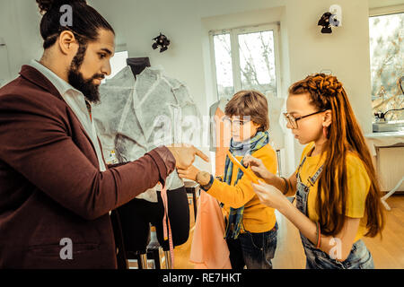 I Capelli rossi ragazza con una bella acconciatura facendo alcune note su tablet Foto Stock