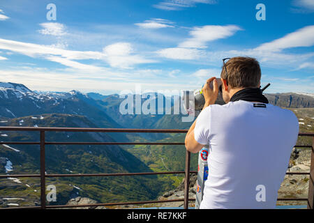 Dalsnibba, Norvegia - 26.06.2018: l'uomo cerca nel binocolo sul punto di vista Dalsnibba, vista del fiordo Gejranger, Norvegia Foto Stock