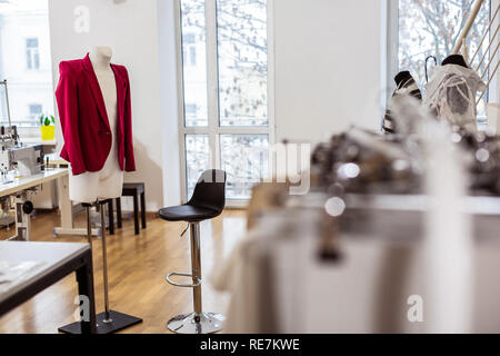 Bella giacca rossa per le donne appeso su un manichino in un centro di un studio di moda Foto Stock