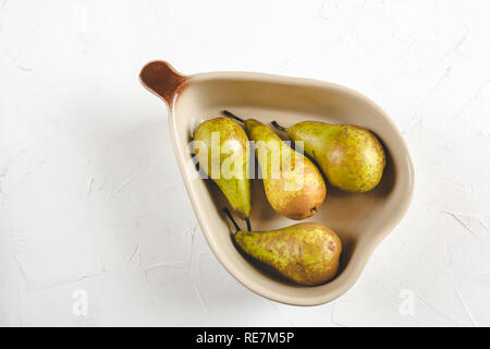 Pere fresche in un piatto su sfondo bianco Foto Stock