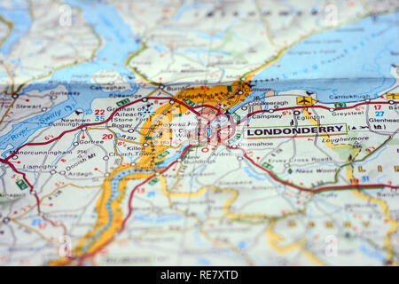 Selettivamente concentrati città di Londonderry su una mappa su carta con il confine tra Nord Irlanda e Repubblica Irlandese Foto Stock