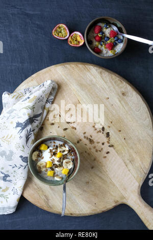 Una sana prima colazione. Porridge con banana, mirtilli, lamponi, frutto della passione, mango e semi. Foto Stock