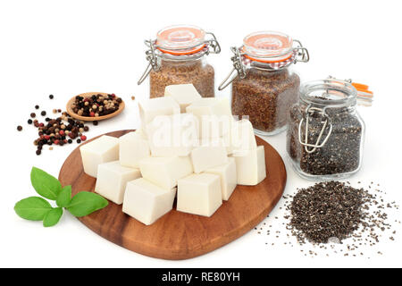 Vegan health food con tofu tofu, lino e chia. Semi di erba di basilico e chicchi di pepe nero su sfondo bianco. Super alimenti ad alto contenuto di proteine e di omega 3. Foto Stock