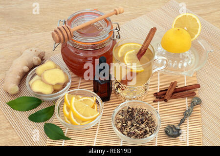 Influenza naturale e rimedio a freddo gli ingredienti con erbe di echinacea, olio di eucalipto, zenzero fresco, limone, bastoncini di cannella e miele. Foto Stock