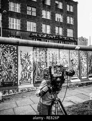 Agosto 1986, CBS cameraman TV, muro di Berlino decorate con Statua della Libertà affreschi, Berlino Ovest lato, Germania, Europa Foto Stock