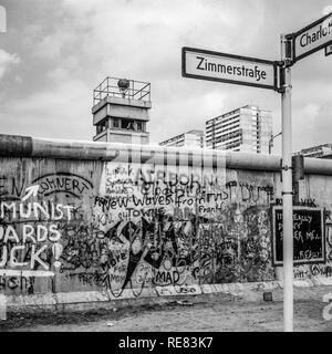 Agosto 1986, graffitis sul muro di Berlino e a Berlino Est torre di avvistamento, Zimmerstrasse strada segno, Kreuzberg, Berlino Ovest lato, Germania, Europa Foto Stock