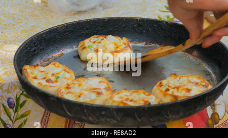 Baker di prelevare acqua calda mini torte con pollo e formaggio in street food festival. Cucina Outdoor, servizio, gastronomia e cibo da asporto concept Foto Stock