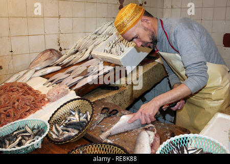 Pescivendolo sfilettatura pesce nella Medina di Fez, Marocco Foto Stock