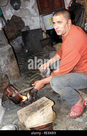 Carpentiere metallico nella sua officina a posto el Seffarine, Medina di Fes el Bali, Fez, in Marocco Foto Stock