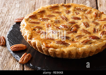 Preparate di fresco di noci pecan tagliate a crostata con cannella e vaniglia su un scheda di ardesia sul tavolo orizzontale. Foto Stock