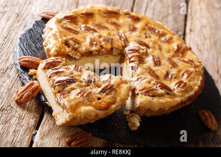 Deliziosi americano a fette di torta alle noci pecan vicino sul tavolo. orizzontale, stile rustico Foto Stock