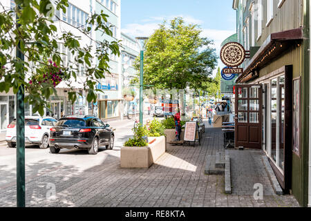 Akureyri, Islanda - 17 Giugno 2018: strada nel villaggio di città in città con il marciapiede e segni forrestaurants memorizza i negozi con le automobili nel traffico Foto Stock