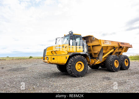 Reykjavik, Islanda - 18 Giugno 2018: costruzione sito con ingrandimento di vibranti giallo auto trattore carrello in Islanda durante nuvoloso giorno di estate con nessuno Foto Stock