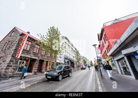 Reykjavik, Islanda - 19 Giugno 2018: persone turisti camminando sulla strada con auto sul bagnato strada piovosa e marciapiede in centro storico Foto Stock