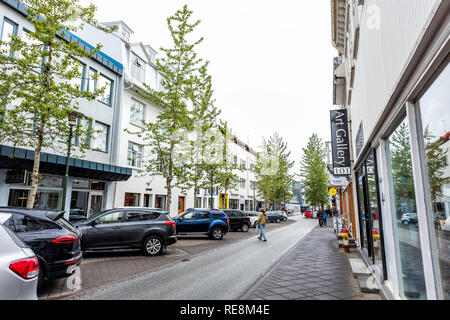 Reykjavik, Islanda - 19 Giugno 2018: strada bagnata strada marciapiede e auto parcheggiate in centro e seguire le indicazioni per la galleria d'arte Foto Stock